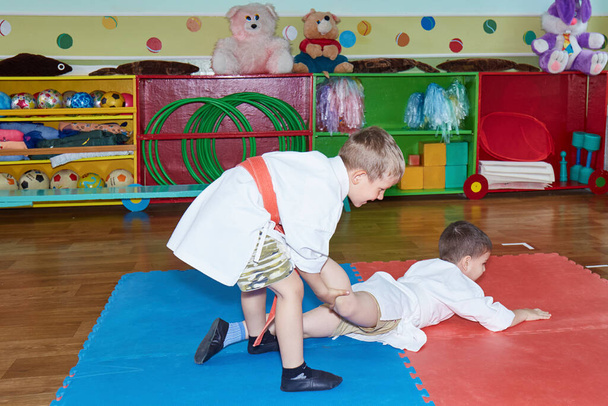 Children train grasps in judogi - Foto, imagen