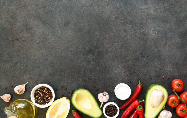 Ingredients for making guacamole sauce. Food on a concrete black table with space for text. - Foto, immagini
