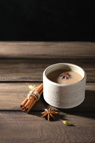 Ceramic cup of masala tea with spice on a wooden table - Valokuva, kuva