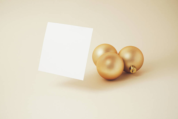Creative New year composition with white paper card and gold Christmas baubles. Minimal holiday concept.  - Foto, Imagen