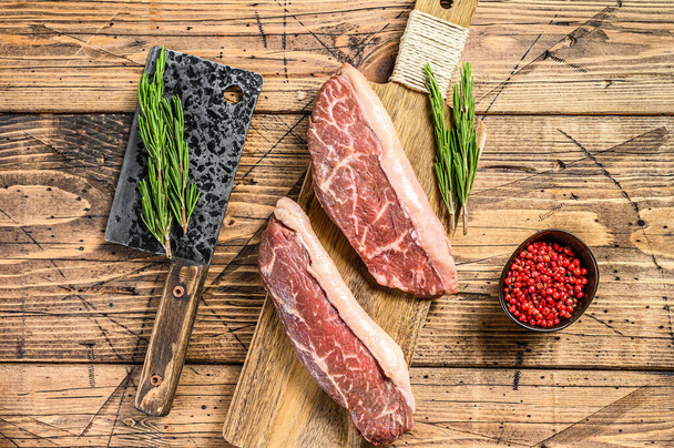 Raw rump cap steak on a chopping Board. wooden background. Top view. - Photo, Image
