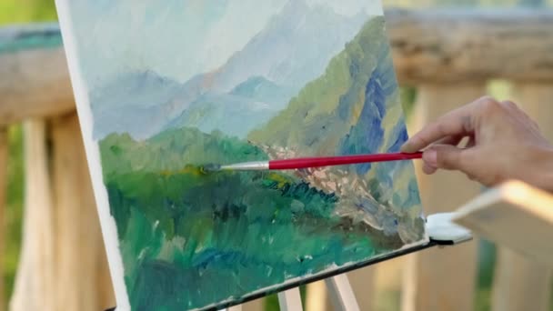Hand van onherkenbare schilder die berglandschap tekent - Video