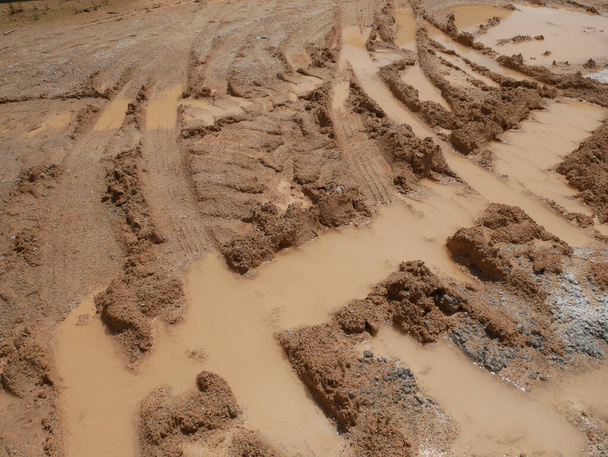 Het teken van zware autobanden die door een modderige grond zijn gegaan.  - Foto, afbeelding