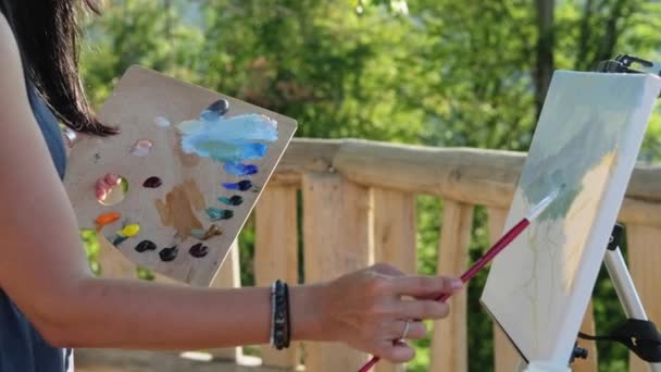 Vrouw kunstenaar schilderen berglandschap buiten - Video