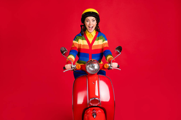 Photo portrait of screaming woman riding scooter isolated on vivid red colored background - Zdjęcie, obraz