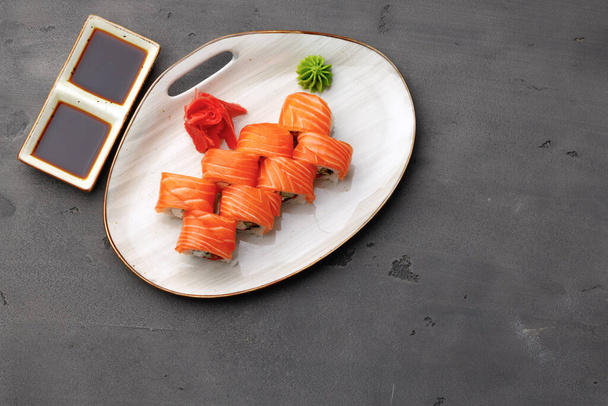 Top view of Philadelphia sushi roll on plate on black table - 写真・画像