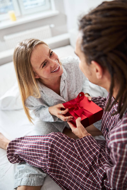 Neşeli genç bir kadın erkek arkadaşından hediye kabul ediyor. - Fotoğraf, Görsel