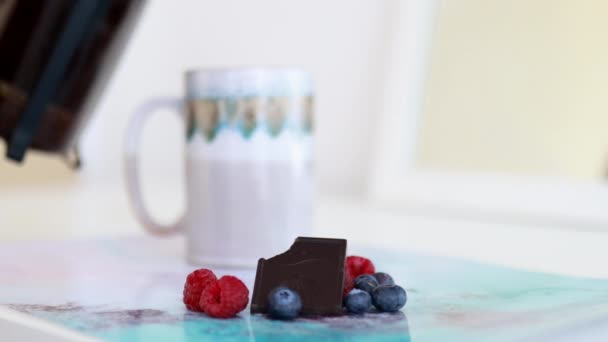 Bitten chocolate bar and berries on a colorful placemat - Footage, Video