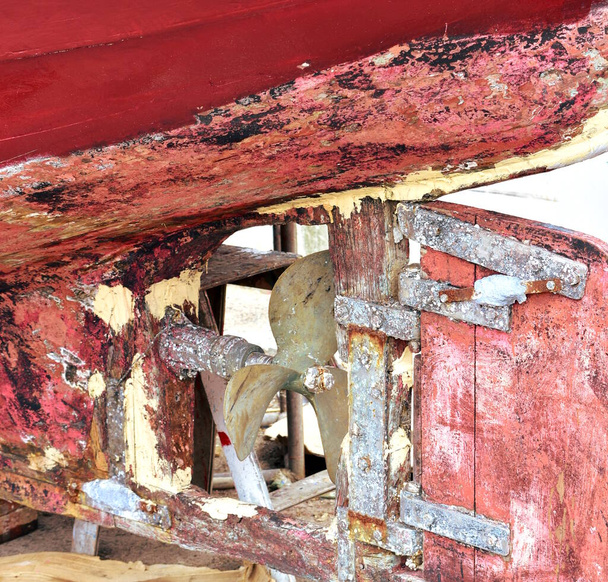 Staré červené dřevěné galicijské rybářské plavidlo v přístavu. Záď, vrtule a kormidlo zblízka. Galicie, Španělsko. - Fotografie, Obrázek