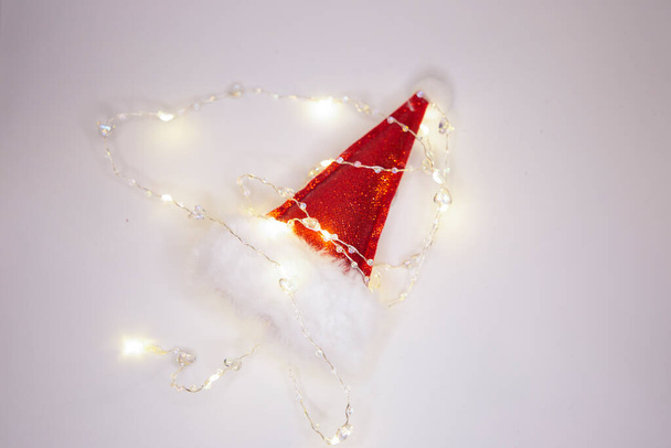 Joyeux Noël et bonne année : chapeau de Père Noël et guirlande électrique - Photo, image
