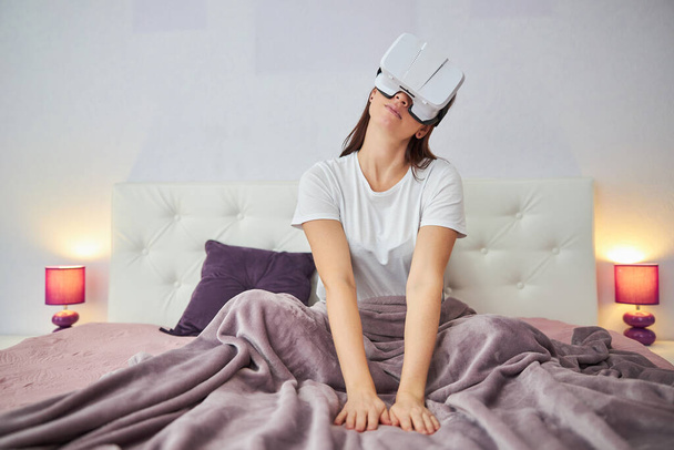 Žena naklání hlavu v helmě virtuální reality - Fotografie, Obrázek
