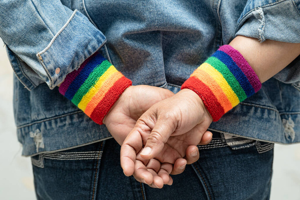 Азійська леді, одягнена в бордові пов'язки веселки, символ ЛГБТ гордості місяця відзначає щорічно в червні соціальні гей, лесбійок, бісексуалів, трансгендерів, прав людини.. - Фото, зображення