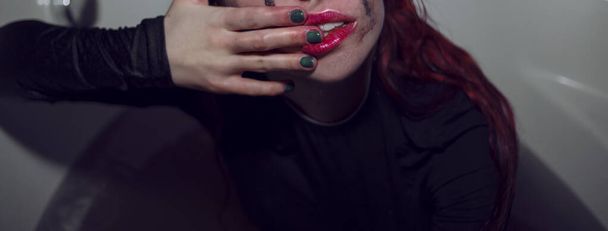 Дівчина з рудим волоссям і чорними відбитками рук на її обличчі
  - Фото, зображення