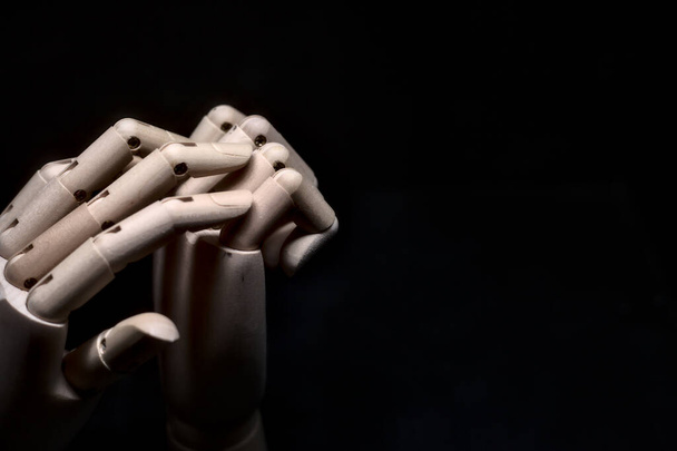 A wooden hand that tries to grasp another wooden hand tightly closed - Foto, immagini
