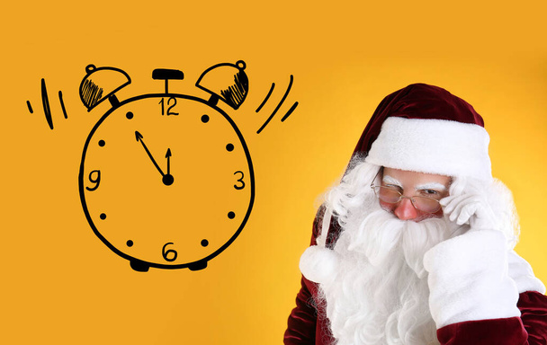 Christmas countdown. Clock showing five minutes to midnight near Santa Claus on yellow background - Foto, imagen