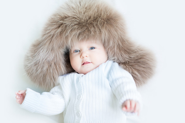 大きい毛皮の帽子を着ての赤ちゃん - 写真・画像