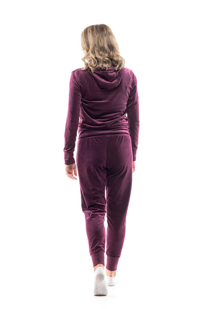 Back view of elegant feminine young woman in home wear leisure sweatsuit walking and looking away. Full body length isolated on white background.  - Photo, image
