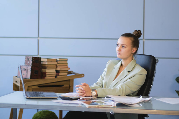 Gelangweilte oder traurige Frau im Bürojob. Negatives Arbeitskonzept. Müde Geschäftsfrau sitzt am Schreibtisch vor dem Laptop und denkt über Probleme nach und zeigt Unzufriedenheit mit ihrer Karriere. - Foto, Bild