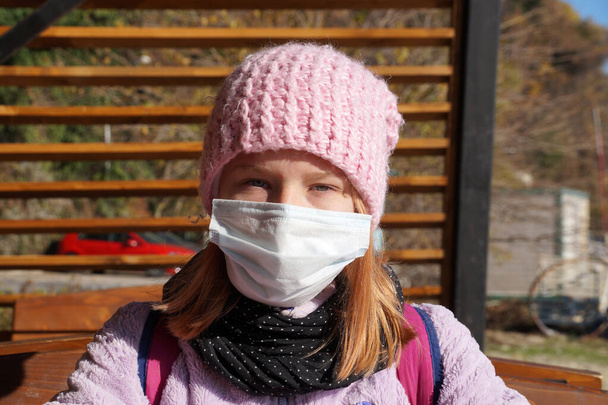 Açık bir kafede tıbbi maske takmış genç bir kızın portresi.. - Fotoğraf, Görsel