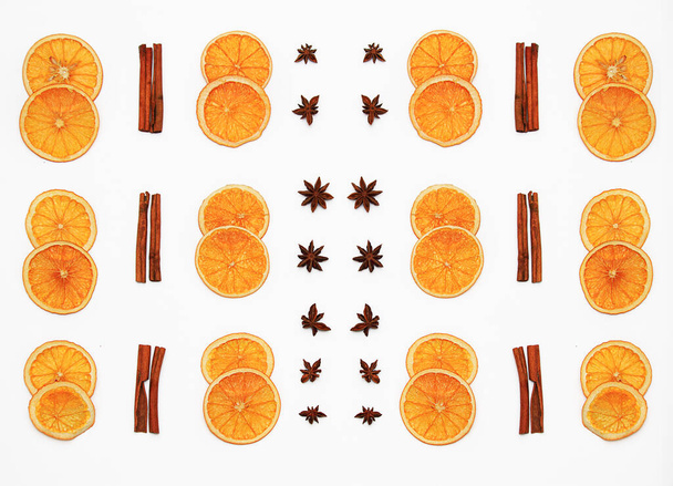 Composition from slices of dried oranges and cinnamon sticks on a white background. Flat lay and copy space.  - Photo, Image