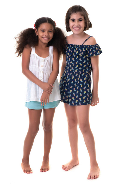 Zwei freundliche kleine Mädchen, Freunde oder Schwestern - hispanisch und afrikanisch-amerikanisch - isoliert auf weiß - Foto, Bild