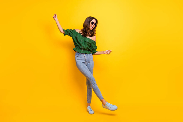 Full body photo of careless pretty joyful young woman raise hands dancer wear glasses isolated on yellow color background - Photo, Image