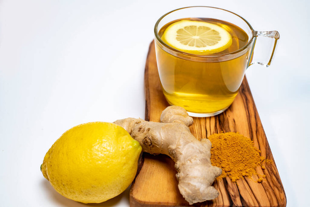 lemon, ginger, turmeric and a cup of lemon tea on an olive board on a white background - Foto, Imagem