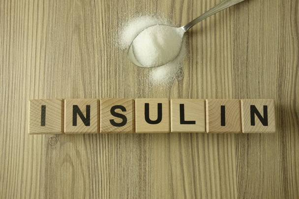 Word ινσουλίνη από ξύλινα μπλοκ με κουτάλι της ζάχαρης, έννοια της υγειονομικής περίθαλψης - Φωτογραφία, εικόνα
