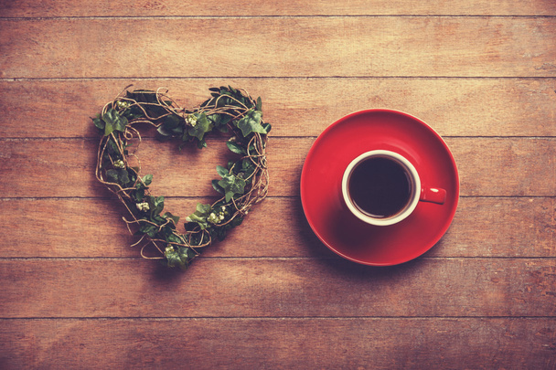 Xícara de café e coração de forma em uma mesa de madeira
. - Foto, Imagem