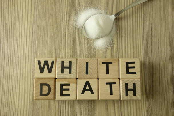 Текст white death from wooden blocks with spoon of salt or sugar, healthcare concept - Фото, изображение