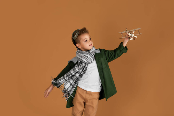 happy child boy playing with wooden toy airplane. dream - Foto, immagini