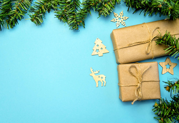 Fond de Noël avec des cadeaux en papier artisanal et un arbre de Noël sur un fond bleu. Carte de voeux de Noël. Le thème des vacances d'hiver. Bonne année. Espace pour le texte - Photo, image