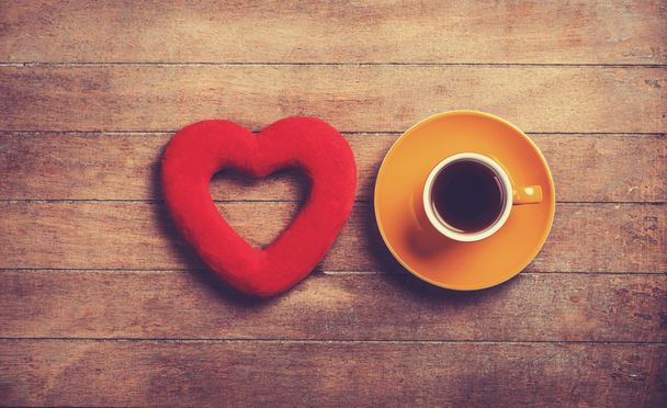 Xícara de café e coração de forma em uma mesa de madeira
. - Foto, Imagem