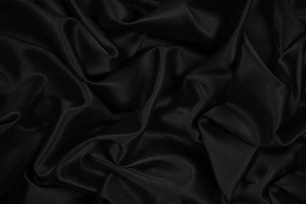 Satén de seda negro. Fondo de tela brillante elegante negro. Hermoso fondo abstracto. - Foto, Imagen