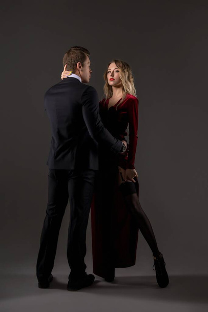 Affectionate young couple in elegant outfits dancing in studio - Foto, imagen