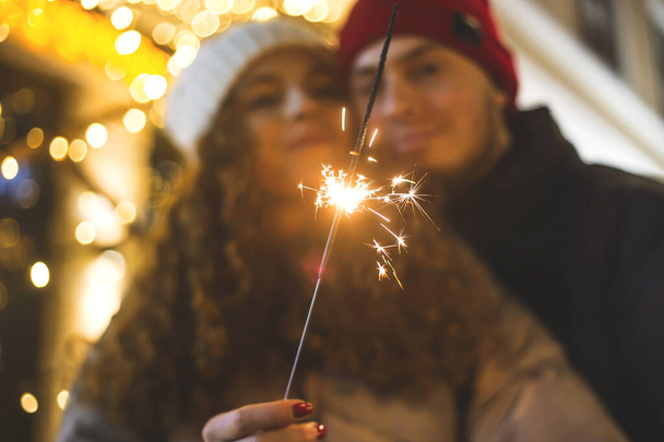 Coppia innamorata in sfocatura con natalizio sparkler - Foto, immagini