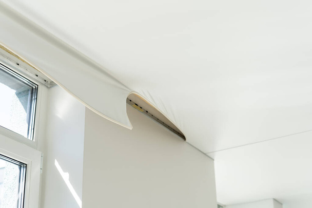 reparateurs te installeren stretch plafond gemaakt van pvc vinyl film met behulp van een gas warmtepistool - Foto, afbeelding