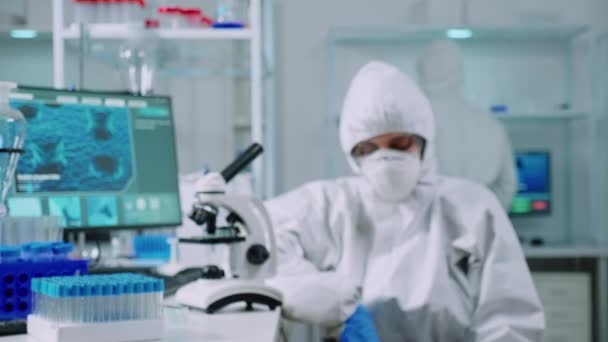 Professional scientist in protection suit looking tired at camera - Footage, Video