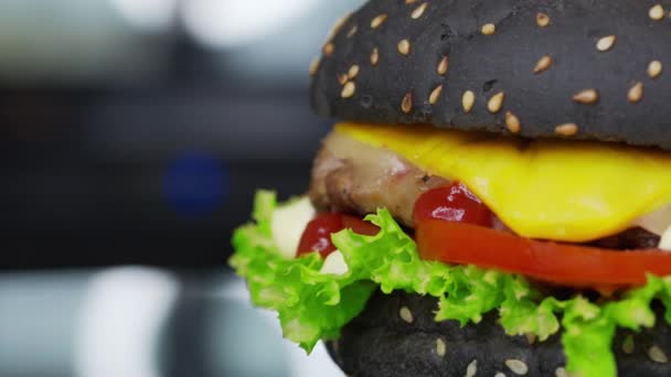 Κοντινό πλάνο του μεγάλου burger tasy με μοσχαρίσια μπριζόλα, λάχανο παγόβουνο, ντομάτες, λιωμένο τυρί, περιστρεφόμενο - fast food, προετοιμασία τροφίμων 4k πλάνα. - Πλάνα, βίντεο