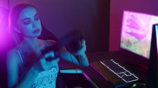 Seksowna młoda kobieta zakłada słuchawki i gra w gry w klubie gier - Materiał filmowy, wideo