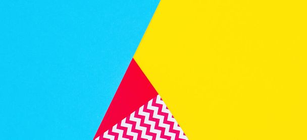 Абстрактні геометричні модні папери текстурують фон жовтого, світло-рожевого, синього кольорів. Вид зверху, плоский ліжко
 - Фото, зображення