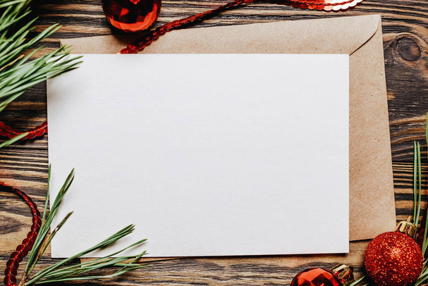 Blank note with fir branch and Christmas toys on wooden background. New Year concept - Фото, изображение