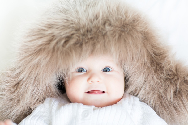 Baby wearing a big fur hat - Фото, изображение