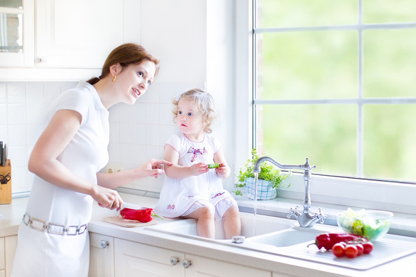 Äiti ja hänen tyttärensä pestä vihanneksia
 - Valokuva, kuva