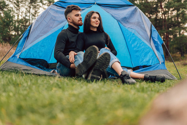 Young tourister couple sitting near tent - Foto, imagen