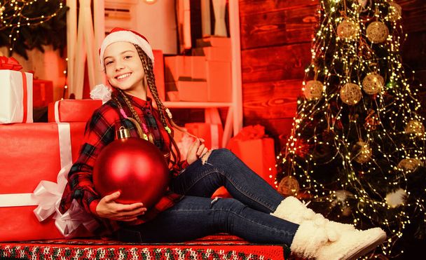 Christmas concept. Child fancy santa enjoy celebration new year. Decor shop. Favorite color. Red style. Spread love. Winter holiday. Small cute girl with big ball christmas tree. Christmas spirit - Foto, Bild
