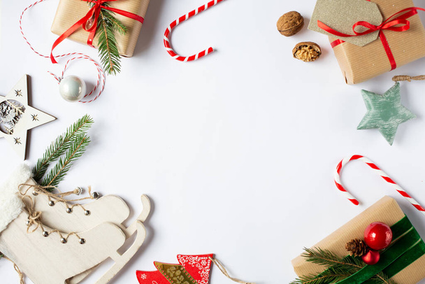 クリスマスの装飾は画像の周囲に位置しています。贈り物、装飾的なスケートやボールなどの新年の装飾。中央のテキストのための無料スペース。上からの眺め.  - 写真・画像