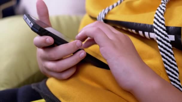 Prsty dospívající listovat přes textové zprávy a hrát na smartphone doma - Záběry, video