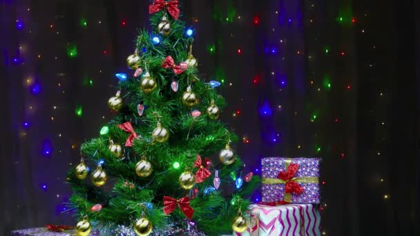 Красиво украшенные елка и подарки на фоне мигающих огней - Кадры, видео
