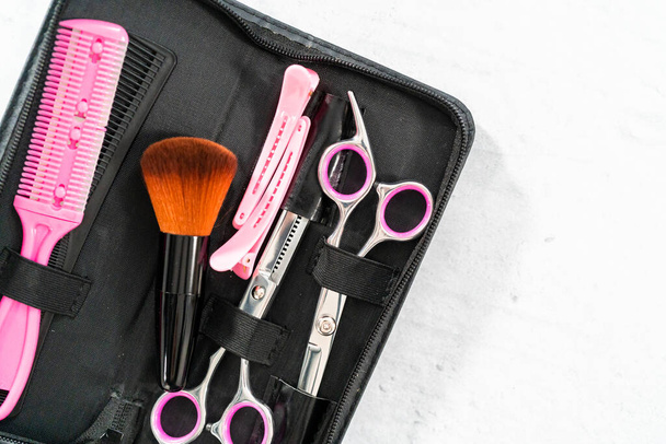 New barber set with pink scissors on a gray background. - Foto, Imagen